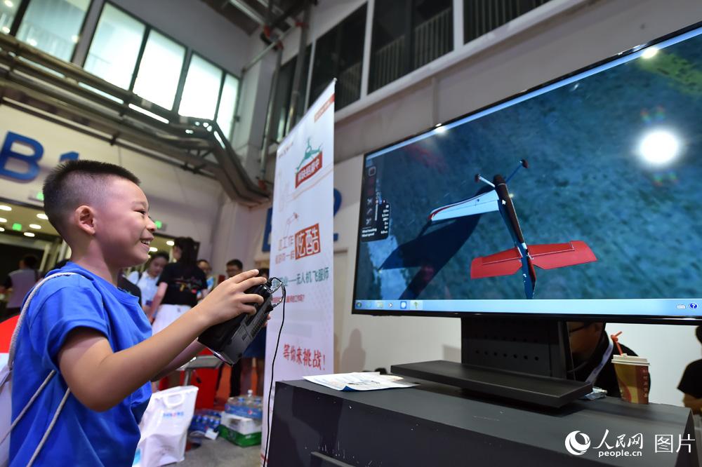 8月23日，展览现场，小朋友正在操控模拟飞机。（人民网记者 翁奇羽摄）