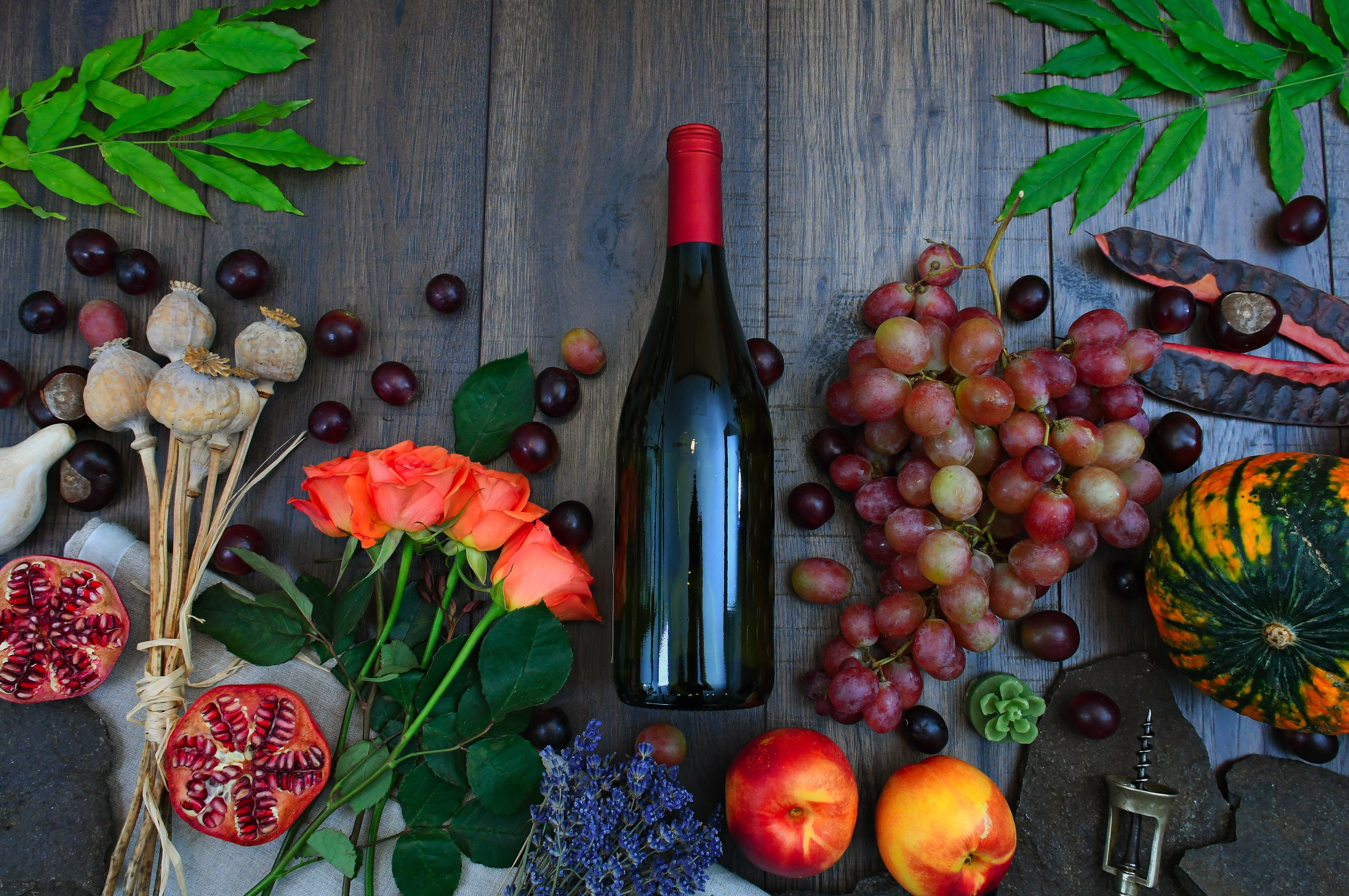 1575944879wine-bottle-beside-grapes-roses-and-several-fruits-on-brown-1407857.jpg?size=4011901